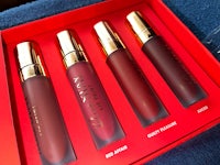 four lip glosses in a red box